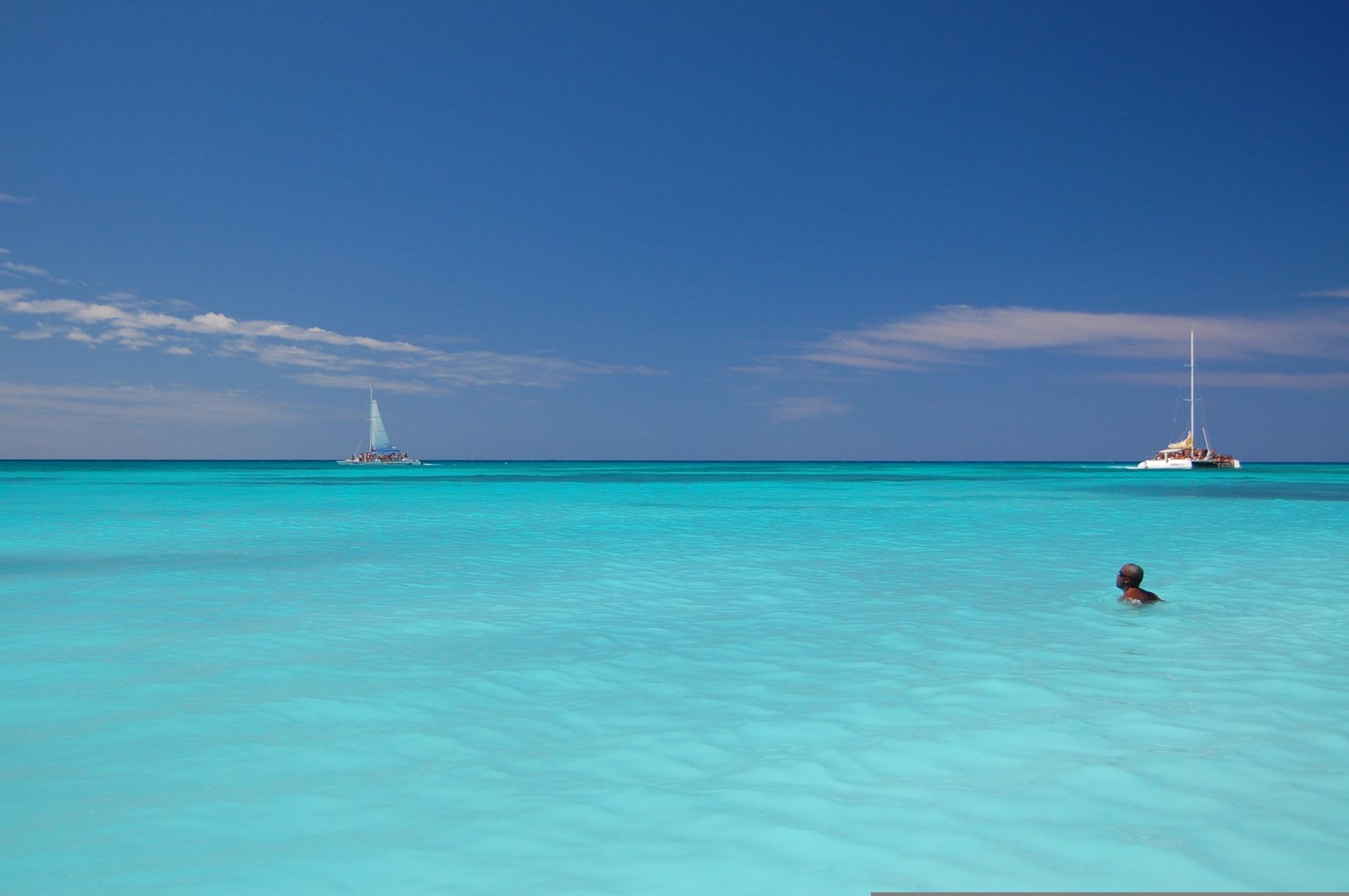 Catamaranes sobre agua turquesa rumbo a la isla Saona, República Dominicana